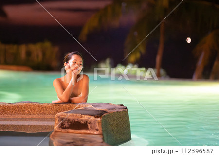 夜のプールで寛ぐ女性 112396587