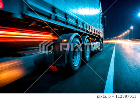 auto transportation logistics. large truck speeds along a highway at night, illuminated by bright streetlights, efficiency and speed of modern logistics and freight transportation auto transportation logistics. large truck speeds along a highway at night, illuminated by bright streetlights, efficiency and speed of modern logistics and freight transportation 112397013