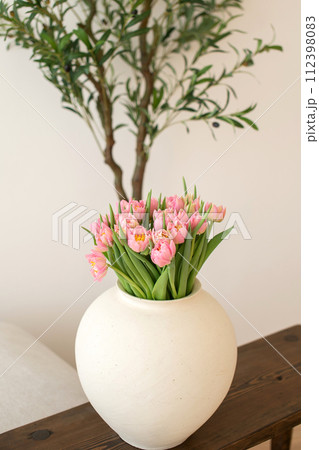 Pink tulips in white vase on wooden table. Pink tulips in white vase on wooden table. 112398083
