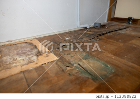 ずっと洗濯機を置いていたため、腐って剥がれてきている家の床（フローリング） 112398822