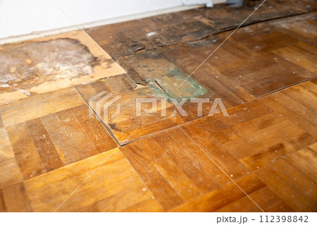ずっと洗濯機を置いていたため、腐って剥がれてきている家の床（フローリング） 112398842