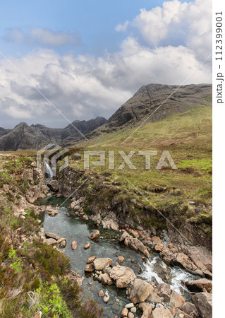 Crisp waters flow among rocks in untouched Highland Fairy Pools, showcasing raw nature Crisp waters flow among rocks in untouched Highland Fairy Pools, showcasing raw nature 112399001