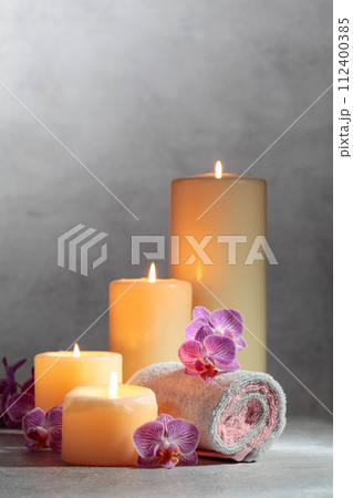 Towels, orchid flowers, and burning candles. 112400385