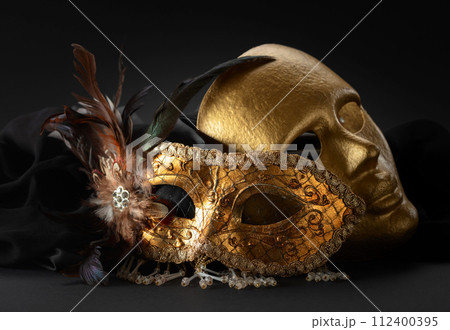 Golden Venetian carnival masks on a black background. Golden Venetian carnival masks on a black background. 112400395