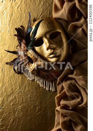 Vintage Venetian carnival masks masks on a golden background. Vintage Venetian carnival masks masks on a golden background. 112400396