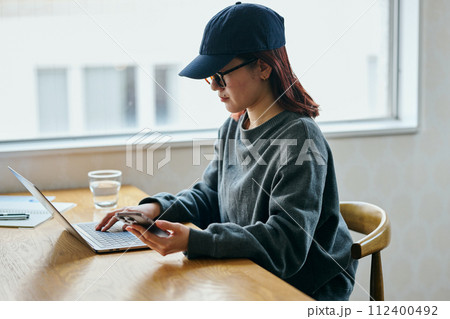 パソコンをタイピングする若い女性 パソコンをタイピングする若い女性 112400492