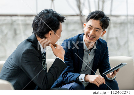 笑顔で打ち合わせをする2人の男性ビジネスマン 112402273