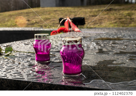 Lamps for a monument, candlesticks for candles stand on a marble pedestal after rain on the street 112402370