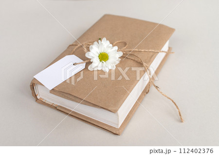 Kraft cover book with white tag, gift wrapping, top view, white label, mockup for text 112402376