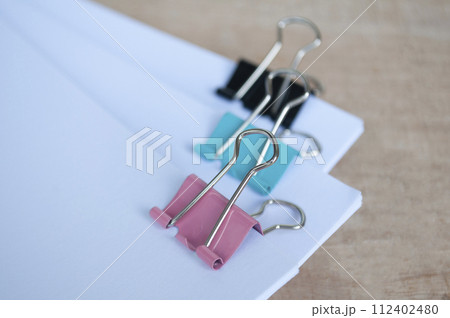 Blank document papers with paper clips pastel on wooden table. Document management concept. Blank document papers with paper clips pastel on wooden table. Document management concept. 112402480