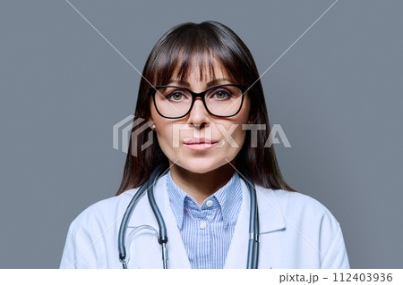 Headshot portrait serious female doctor looking at camera on gray background 112403936