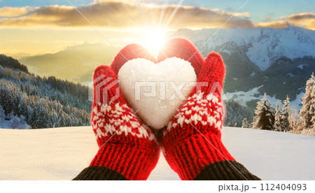 Female Hands in Red Knitted Mittens Holding a Heart Made of Snow - Generative Ai 112404093