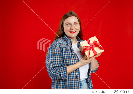 Portrait of cheerful, happy woman receive gift, smiling excited. Girl holding wrapped present, celebrating birthday on red background. Valentine's Day Women's Day birthday holiday concept. 112404558
