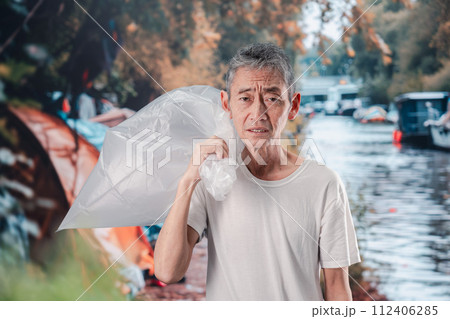 ゴミ拾いをするホームレスの男性 112406285