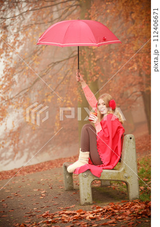 Girl in autumn park enjoying hot drink Girl in autumn park enjoying hot drink 112406671