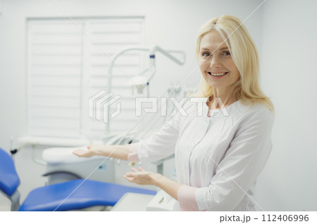 Woman working in dental clinic and doctor in background. Woman working in dental clinic and doctor in background. 112406996