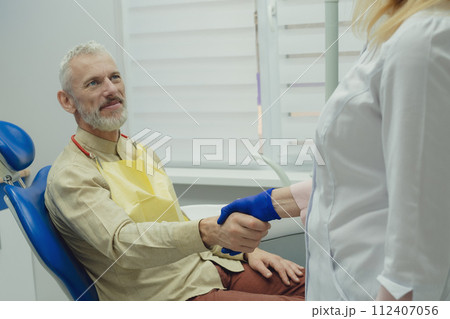 Male smiling during her dental treatment at dentist. Male smiling during her dental treatment at dentist. 112407056