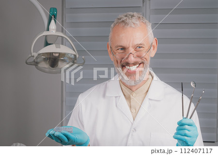 Portrait of attractive handsome dentist with haircut, white lab coat. Portrait of attractive handsome dentist with haircut, white lab coat. 112407117