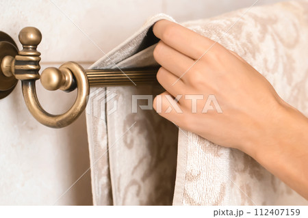 Girl is hanging clean towel on a holder. Girl is hanging clean towel on a holder. 112407159