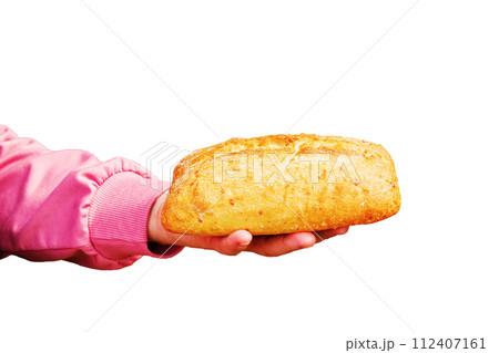 Bread in the hand of a middle-aged woman. The concept of the world food crisis associated with the war in Ukraine. Isolated on white background 112407161
