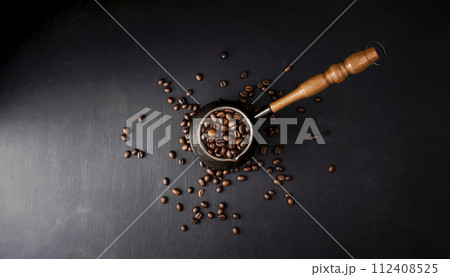 Hot coffee in turkish (cezve) and roasted coffee beans on black background. Turkish coffee Hot coffee in turkish (cezve) and roasted coffee beans on black background. Turkish coffee 112408525