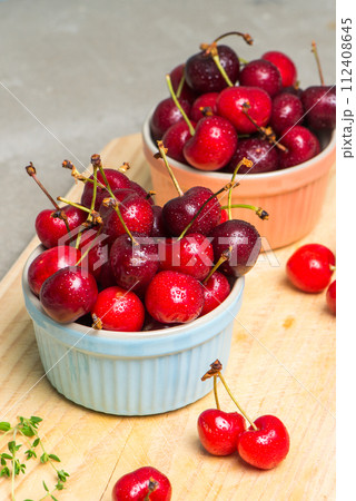 Red ripe cherries in ceramic bowls 112408645
