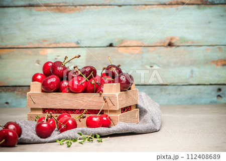 Red ripe cherries in small wooden box Red ripe cherries in small wooden box 112408689