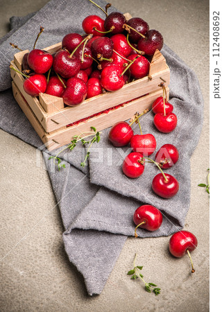 Red ripe cherries in small wooden box Red ripe cherries in small wooden box 112408692
