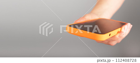 Hand holding mobile phone, smartphone, cellphone closeup. Banner background, copy space for text Hand holding mobile phone, smartphone, cellphone closeup. Banner background, copy space for text 112408728