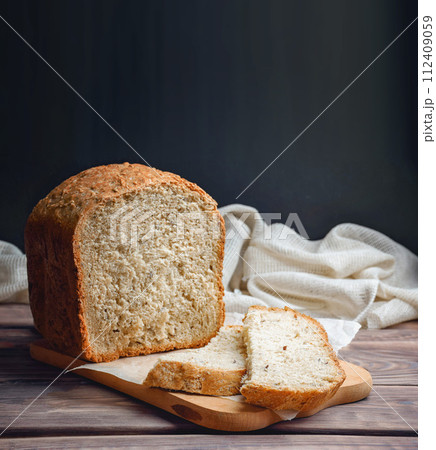 Homebaked bread sourdough  bread with seeds cut into slices lies on a cutting board. Loaf of bread , 112409059