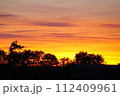 オレンジ色に輝く朝焼けの空 112409961
