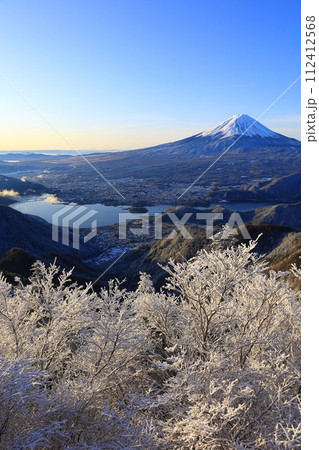 雪の新道峠から眺める朝日を浴びる富士山と河口湖 112412568