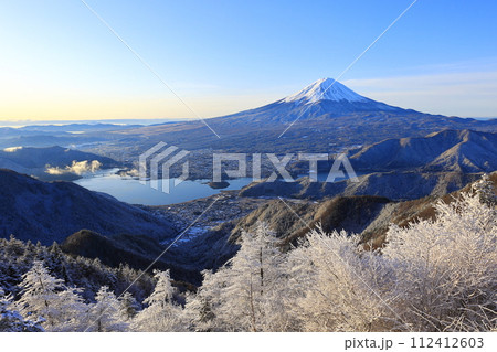 雪の新道峠から眺める朝日を浴びる富士山と河口湖 112412603