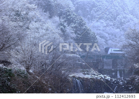 雪の舞う田原の滝と富士急行 112412693