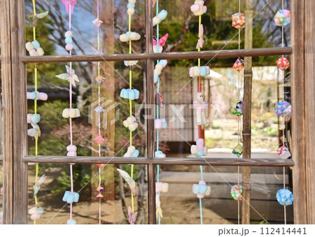 旧家のガラス戸越しに眺める吊るし飾り 112414441
