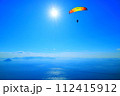 パラグライダー　快晴の王子ヶ岳で飛行するパイロット 112415912