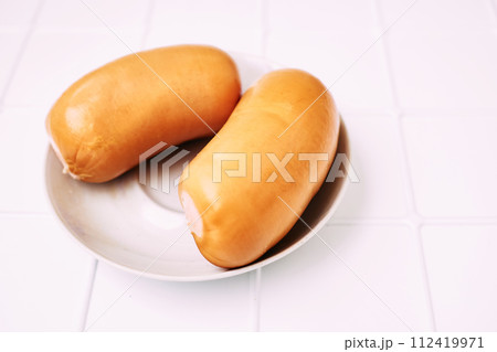 Two fresh meat sausages on a plate, ready to eat 112419971