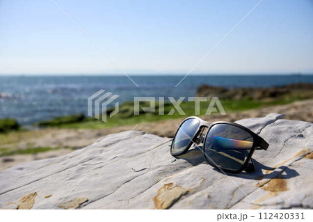 【南知多】海岸の岩場に置かれたサングラス 112420331