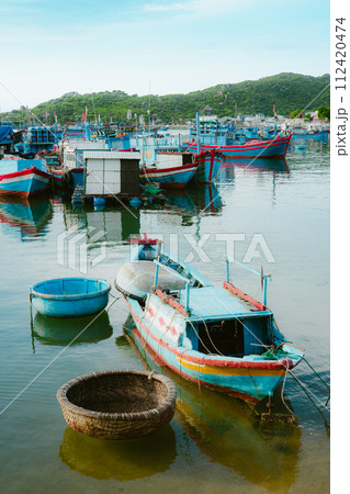 boats anchored on the shore of a small harbor 112420474