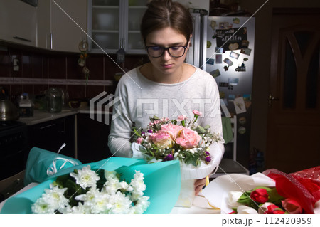 A female florist works on a beautiful bouquet at night in her fl 112420959