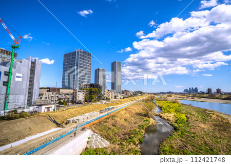 日本の東京都市景観 3月…二子玉川駅近くの多摩川や護岸工事。右奥は武蔵小杉駅前のタワーマンション群 112421748