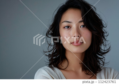 Beauty portrait of a natural young Japanese woman with a soft grey copy space background 112423761