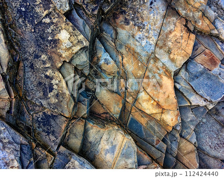 Weathered rocks with intricate patterns and a mix of dark and light colors are tightly packed. Weathered rocks with intricate patterns and a mix of dark and light colors are tightly packed. 112424440