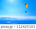 パラグライダー　快晴の王子ヶ岳で飛行するパイロット 112425101