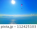 パラグライダー　快晴の王子ヶ岳で飛行するパイロット 112425103