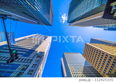 日本の東京都市景観 3月。大手町駅前の摩天楼。左側が大手町(野村ビル)。右側は丸の内のビル群…青信号 日本の東京都市景観 3月。大手町駅前の摩天楼。左側が大手町(野村ビル)。右側は丸の内のビル群…青信号 112425335