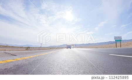 Embarking on a road trip from Nevada to California, driving on Highway 15 during the day offers scenic views and an exciting journey between states. 112425895