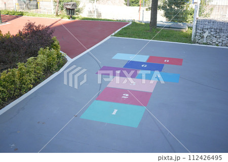 Vibrant hopscotch game painted on urban asphalt surface 112426495