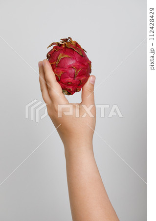 Fresh pitahaya in female hand on white background. Dragon fruit. Fresh pitahaya in female hand on white background. Dragon fruit. 112428429