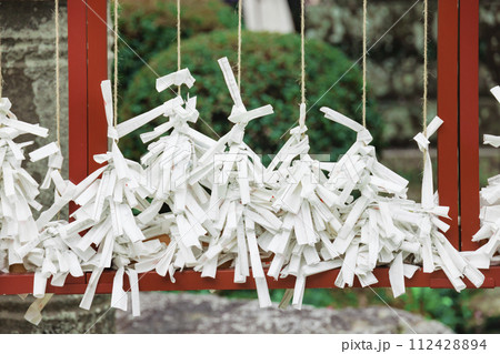 紐に結ばれた占いの紙　おみくじ 112428894